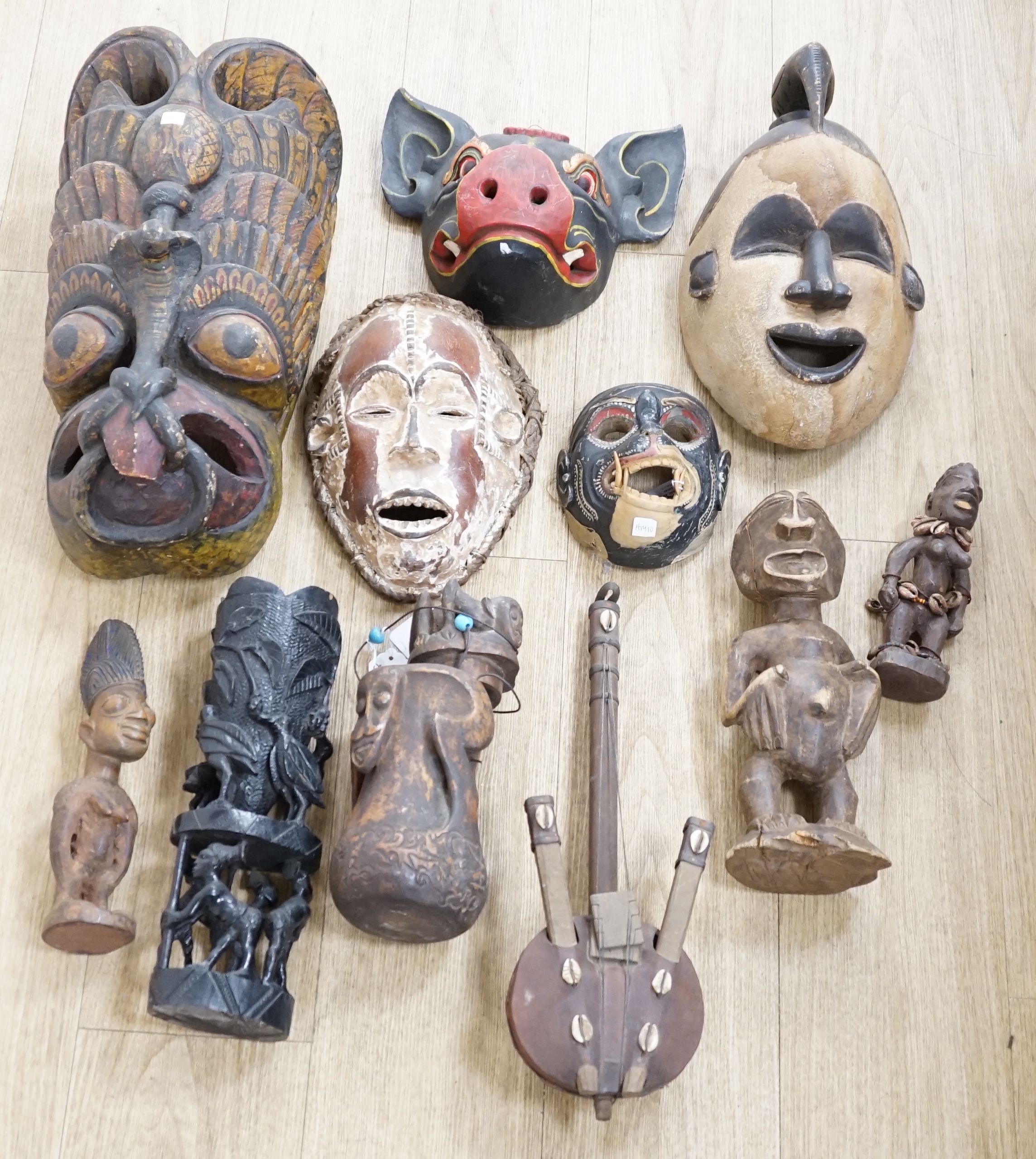 Eight Yoruba carved wood tribal figures and a terracotta vessel (9), largest 35cm high